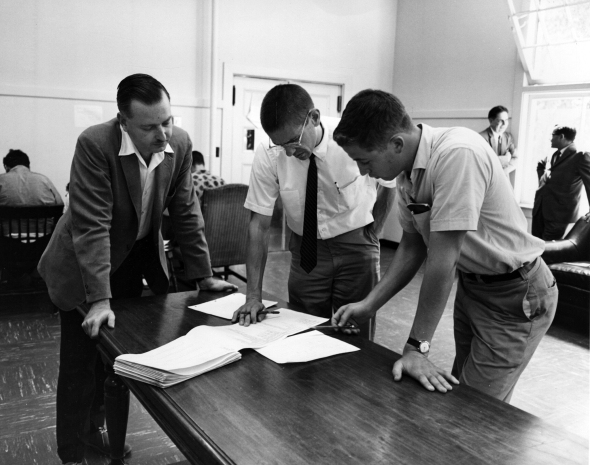 John Kemeny and Thomas Kurtz discuss a BASIC program printout with a student