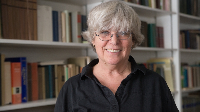 Woman smiling in front of bookcase.