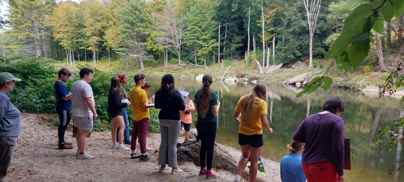Students standing near water.