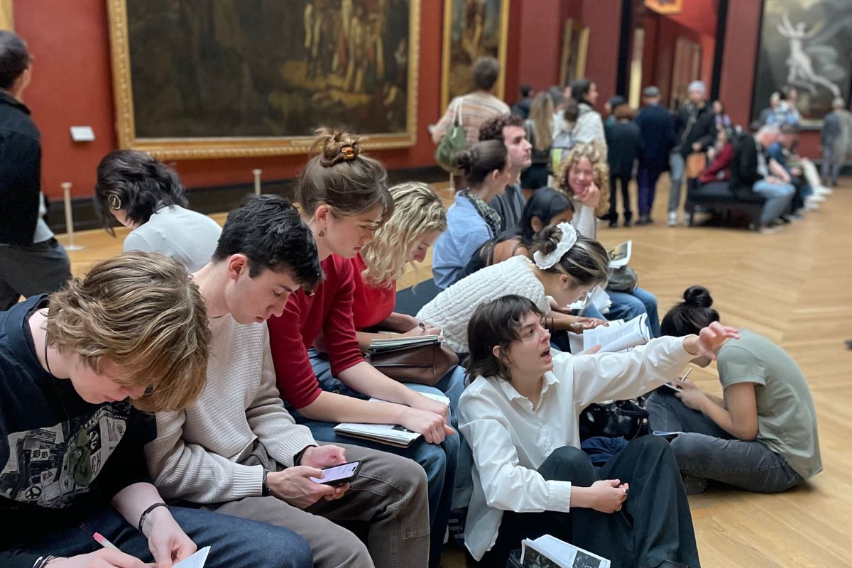 Students examine artwork in the permanent collection of the Louvre.