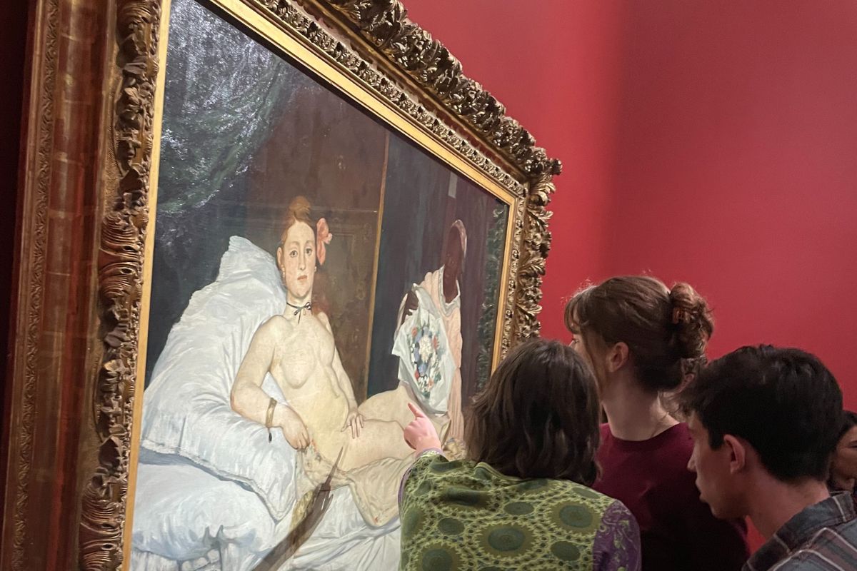 Students look closely at "Olympia" (1863) by Édouard Manet.
