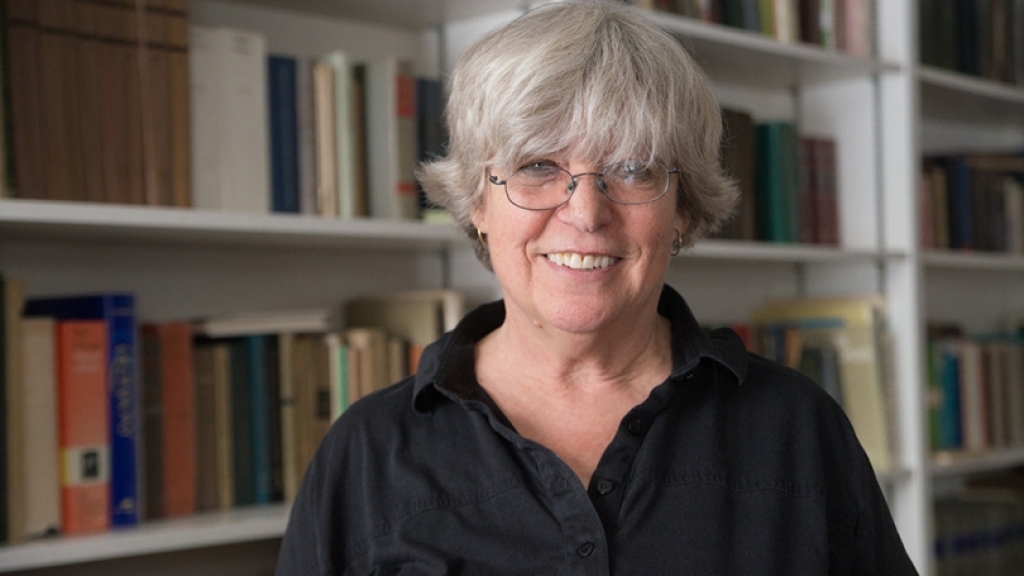 Woman smiling in front of bookcase.