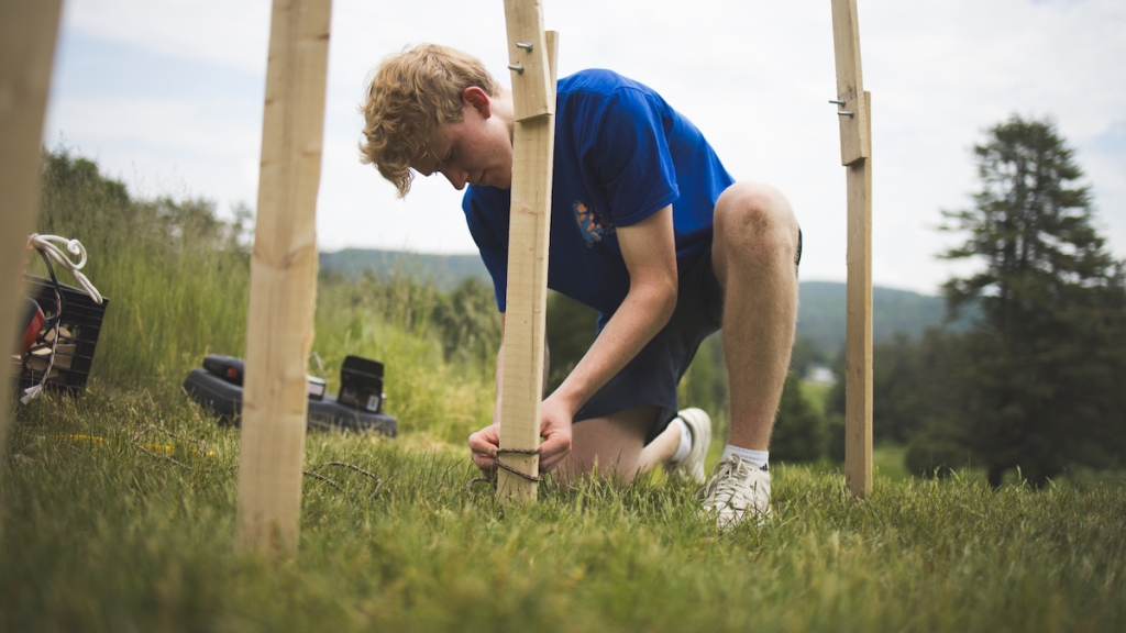 Studio art major Alden Wilcox '26 installs his Pine Cone Pavilion as part of the Pine Park Biennial.